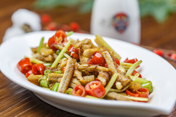 Hunan-style stir-fried eel slices in a leaf-shaped porcelain plate