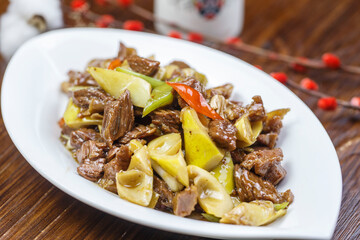 Stir-fried pork with spring bamboo shoots in a leaf-shaped porcelain plate