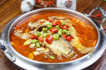 Tilapia in spicy sour soup in stainless steel pot