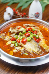 Tilapia in spicy sour soup in stainless steel pot