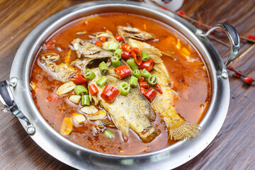 Tilapia in spicy sour soup in stainless steel pot