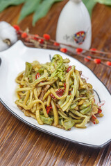 Stir-fried pork belly with gongcai served in a white porcelain plate