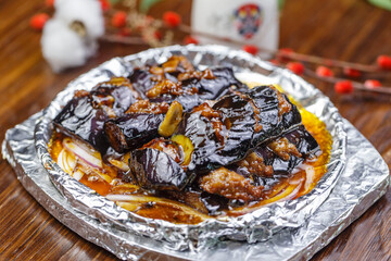 Iron plate with minced meat and eggplant in sauce