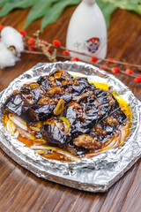 Iron plate with minced meat and eggplant in sauce