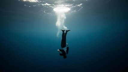 Man in Suit Descending Underwater with Bubbles in Dramatic Blue Ocean Environment - Powered by Adobe