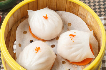 Cantonese prawn dumplings in a steamer are placed on a tablecloth