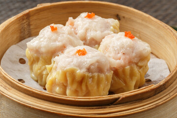 Cantonese prawn dumplings in a steamer are placed on a tablecloth