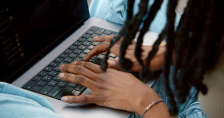 Software developer writing code on laptop keyboard, close-up view