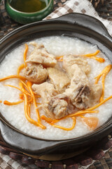 Cordyceps flower pork ribs porridge in a black casserole placed on the tablecloth
