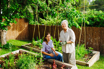 Women gardening together in backyard vegetable garden
