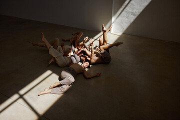 Group of dancers engaged in collaborative movement under natural