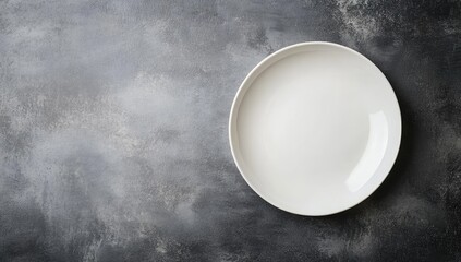 Empty white plate on a gray textured surface