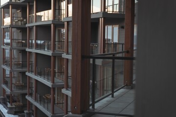 Flat design is showing multi story balcony facade with glass railings, tiled floor, snow on ground