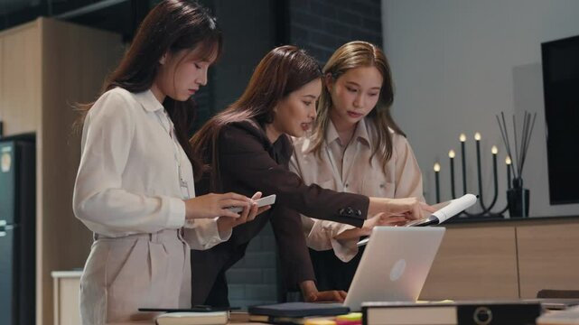 Supervisor guiding mentor training new trainee in Asian office environment with learning focus and clarity
