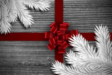 Obraz premium Flat-lay design is featuring red satin ribbon crossing grey wood planks with white conifer branches