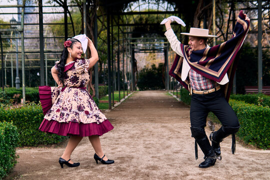 A pair of young Chilean Latin dancers dancing cuecas, the Chilean national dance, in a very cheerful, charismatic, and romantic manner. Chilean Independence Day celebration.
