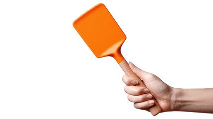 Hand holding an orange spatula, isolated on white background.