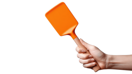 Hand holding an orange spatula, isolated on white background.