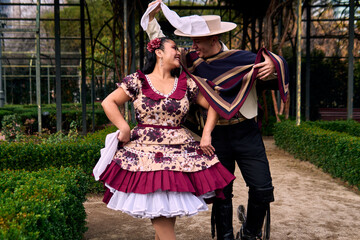 A couple of young Chilean Latin dancers posing romantically and dancing the cueca in a very...