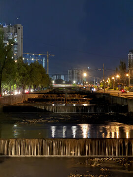 Night view of city canal with cascading water