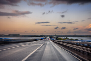 Fototapeta premium Speed on bridge. Dynamic car motion. Evening horizon