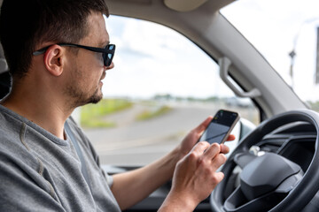 Driver with phone. Man using smartphone in car. GPS navigation checking.