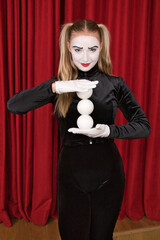 On stage is a pantomime artist with white balls.