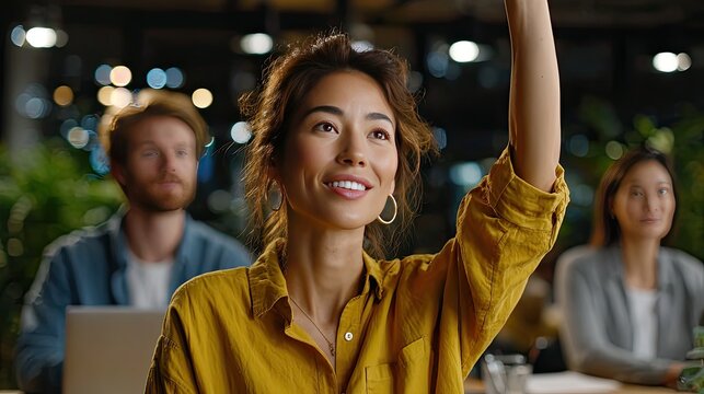 Confident Question: A woman with a warm smile raises her hand in a gesture of inquiry during a meeting. The office setting is illuminated by soft lighting, fostering a collaborative environment. - Powered by Adobe