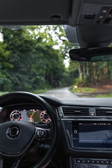 Vertical view from car. Forest road ahead. GPS and travel route.