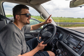Driver gesturing. Driving a car. Highway travel.