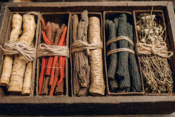Dried herbal roots bundled in wooden box, showcasing natural textures and colors