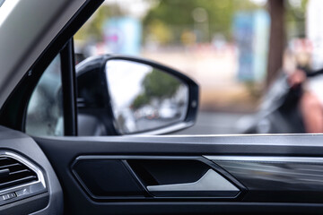 Car interior close-up. Side rearview mirror. Modern vehicle door design.