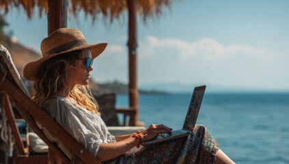 Fototapeta premium Woman working on laptop by the sea