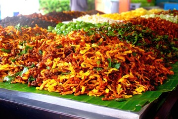 Assorted colorful, spiced, shredded food on banana leaf