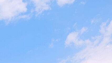 Blue sky background with white clouds in summer. Soft white clouds float in the clear blue sky. Focus on clouds. Full frame shot. Heaven sky bright blue sky background.