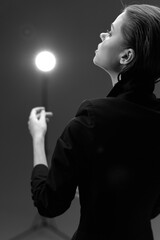 Black and white woman portrait with dramatic lighting, elegant pose, soft focus, and dark...