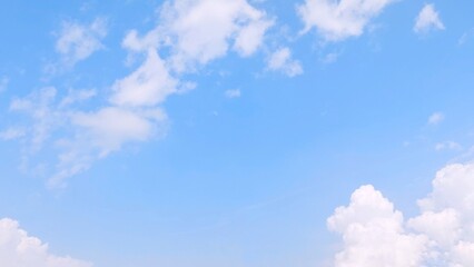 Fototapeta premium Blue sky background with white clouds in summer. Soft white clouds float in the clear blue sky. Focus on clouds. Full frame shot. Heaven sky bright blue sky background.