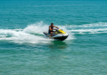 Aerial view of a person on a jet ski creating a wake on blue water.