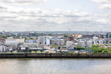 Industrial area. Factory near water. Tanks and pipes.