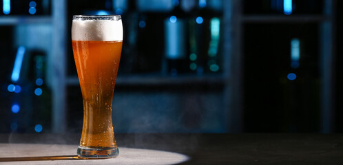 Glass of fresh beer on table in bar