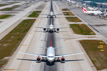 Aerial view of airport with multiple planes on taxiways, 
