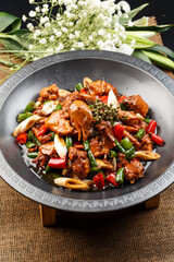 Spicy stir-fried pork belly with celery and pickled mustard greens on a white porcelain plate