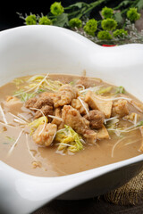 Crispy pork and braised bean curd in a heart-shaped white porcelain soup bowl