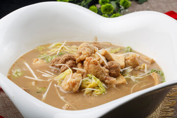 Crispy pork and braised bean curd in a heart-shaped white porcelain soup bowl