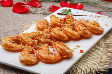 Deep-fried large shrimps with garlic paste in a white oval porcelain plate