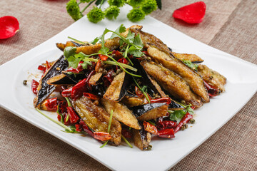 Spicy fried eggplant in white square porcelain plate