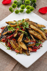 Spicy fried eggplant in white square porcelain plate