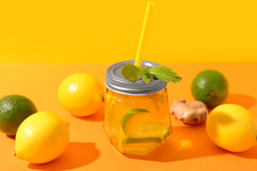 Mason jar of tasty lemonade with lime and mint on colorful background