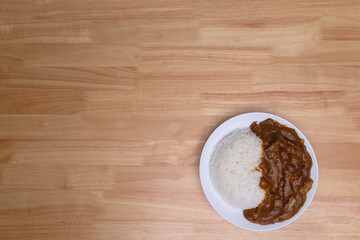 top view of homemade Japanese curry rice with beef carrot beans and onion in white dish on wood table