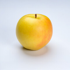 a whole flesh yellow-red orin apple  covered with small water droplet with shadow from backlight a in white background with clipping path